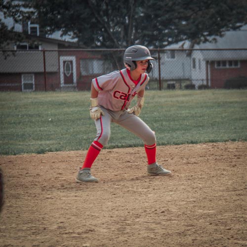 An Elkridge Hurricanes base runner leads off of second base, keeping his eye on the pitcher.