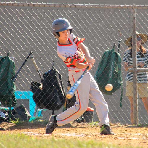 Batter Gabe Paulhamus swinging at a pitched ball that is nearing his bat.
