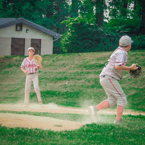 Elkridge Hurricanes pitcher Kaden Ok starting his throw to first base after fielding a ground ball. First baseman Camden Bednar awaits the throw.